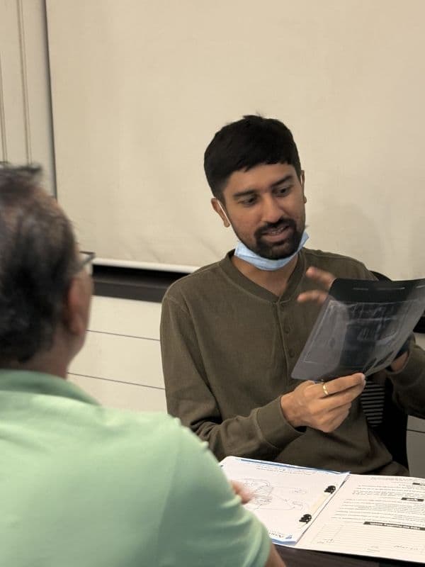 Dr. Pratik Pipalia reviewing dental X-rays and scans with a patient in Rajkot