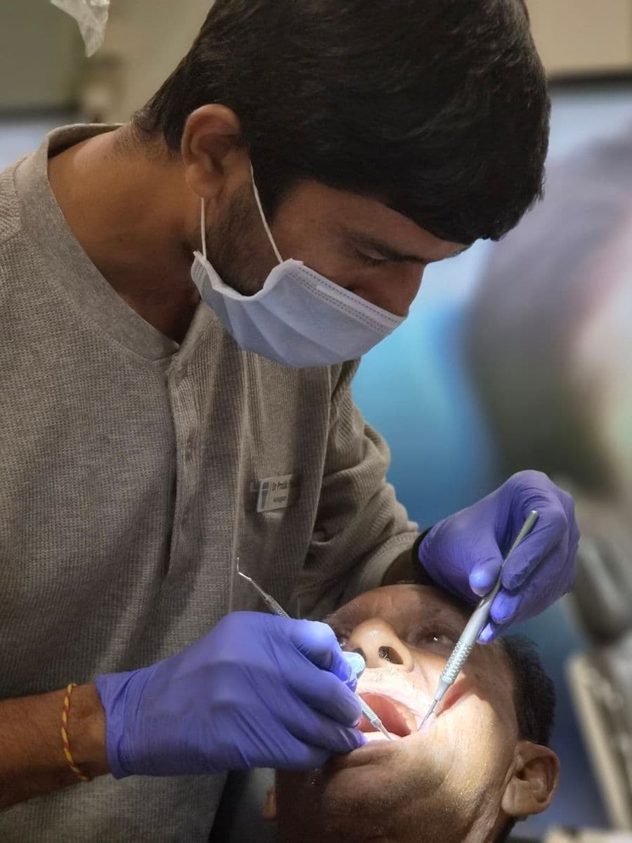 Dr. Pratik Pipalia treating a patient — dental implants specialist in Rajkot, Gujarat